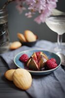 A maple roast fig with raspberries in a small hand thrown blue pottery bowl