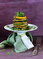 A zucchini and sweet potato tower with a card