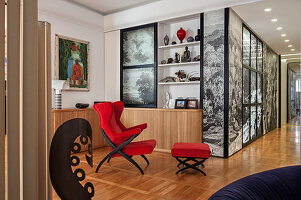 Roter Designersessel mit Fußhocker in offenem Wohnraum