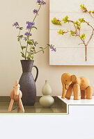 Wooden animal figures and ceramic vases on a sideboard