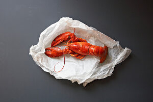 A whole cooked lobster on wihte paper