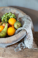 Fruit and cheesecloth in rustic terracotta bowl