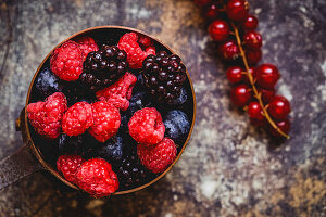Organic raspberries, blueberries, blackberries and redcurrants in a bowl