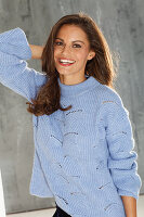 Dunkelhaarige Frau in blauem Strickpullover