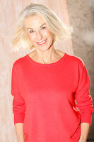Ältere blonde Frau in rotem Pullover