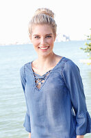 A young blonde woman with a bun wearing a denim blouse