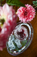 Liqueur in a crystal carafe on a silver tray beside a dahlia