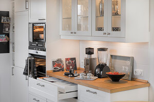 Glass-fronted wall units in white fitted kitchen