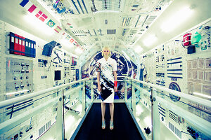 Futuristic Fashion: a blonde woman wearing a short-sleeved dress inside a spaceship