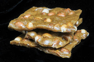 Nut-caramel brittle on a black background