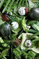 An arrangement of green shades made from vegetables, leaves, flowers and scoops of mint ice cream (full frame)