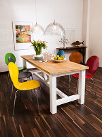 Colourful modern chairs around wooden country-house-style table