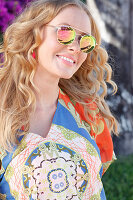 A blonde woman wearing a colourful tunic and sunglasses