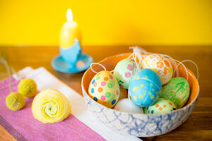 Easter eggs painted with gouache, candle and flowers