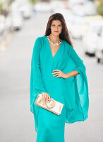A brunette woman wearing an elegant turquoise evening dress