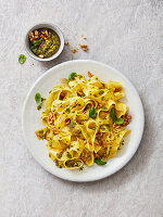 Tagliatelle with garlic and basil pesto, walnuts, pine nuts and basil leaves