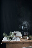 Two glasses of red wine and Christmas decorations on wooden table