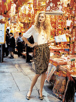 A blonde woman wearing a white blouse and a printed skirt shopping in Hong Kong