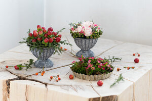 Kleine Blumengestecke in einer Backform und Metallschälchen