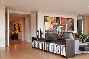 Shelves used as partition against sofa back in large living room