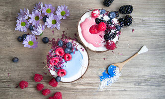 Pink and blue smoothies with coconut and berries (seen from above)