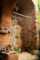 Rustic outdoor shower with bead curtain in stone niche