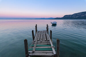 An old wooden jetty at dusk at Lake Garda (Italy)