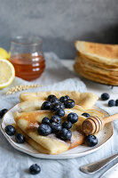 Classic French crepes topped with fresh blueberries and honey