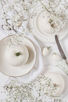 weiße Kürbisse und Miniauberginen als Tischdeko
