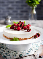 Goat cheese cheesecake with fresh raspberries and mint leaves on top