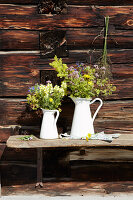 Bunches of wildflowers in white enamel jugs