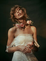 Junge Frau mit Blumenschmuck in weißem Spitzenkleid