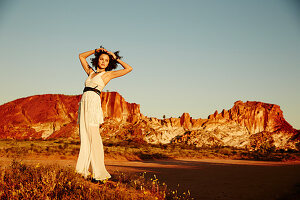 A young woman in the desert wearing a light summer dress