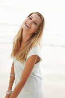 Blonde Frau in weißem Longshirt am Strand