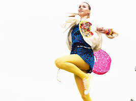 A young blonde woman wearing a blue summer dress and yellow tights