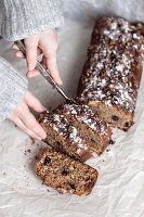 Girls hands, cutting honey gingerbread with Uzbek raisins and walnuts on the Jewish recipe Lekah