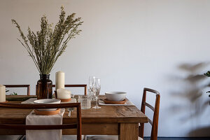 Wooden table set with candle and ears of cereal in apothecary bottle