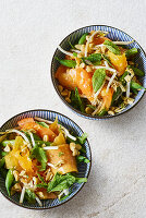 Oriental bowls with papaya salad, nuts and a honey and sesame seed dressing