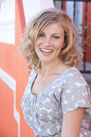 A blonde woman wearing a grey spotted blouse