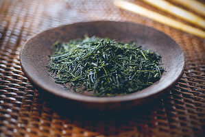 Green tea: tea leaves in a wooden bowl
