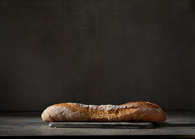 Ein Baguettebrot vor dunklem Hintergrund