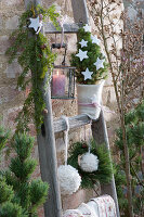 Christmas decorated wooden ladder with sugar loaf spruce and woollen balls