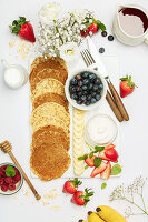 Banana oat pancakes with fruits, berries and maple syrup