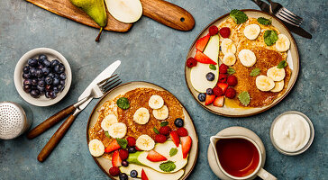 Banana oat pancakes with fruits, berries and maple syrup