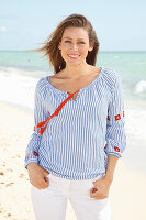 Blonde Frau in blau-weiß gestreifter Bluse am Strand