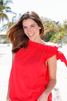 A brunette woman outside wearing a red top