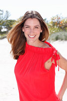 A brunette woman outside wearing a red top