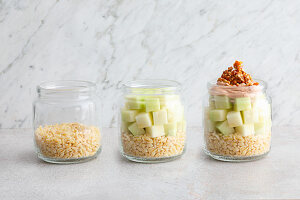 Muesli being layered in a jar