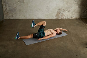 A young man lying on his back with one leg bent up