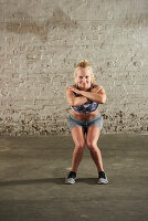 A woman performing a squat with her knees turned in
